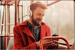 Homem utilizando um smarthphone com fone de ouvido em um ônibus.