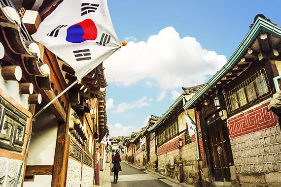 Imagem de uma vila coreana, uma das casas com a bandeira da coreia