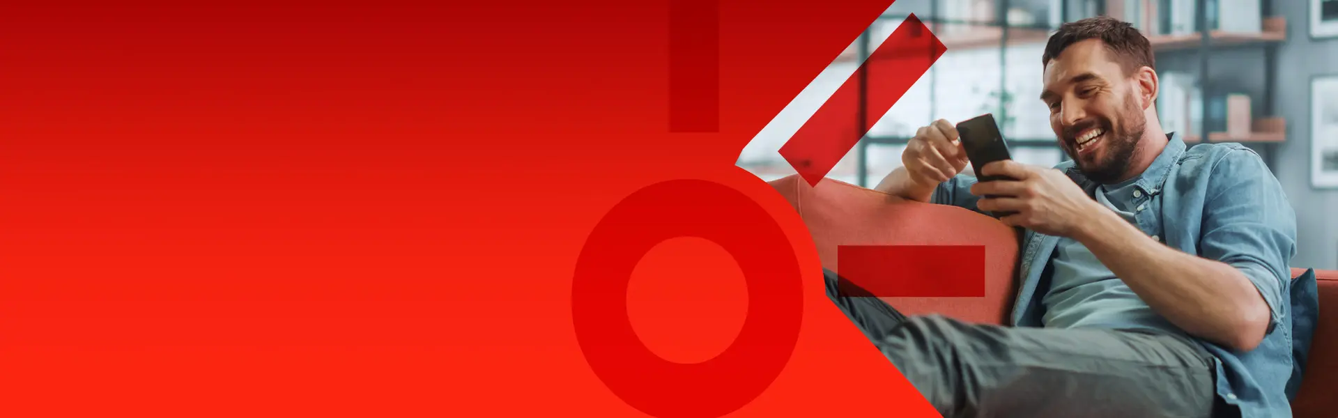 Imagem de um homem sorridente com o celular nas mãos.