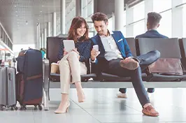 Imagem de um casal conversando num ambiente de aeroporto.