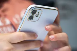 Imagem de uma mão segurando um smartphone.