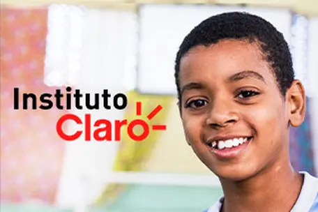 Menino sorrindo ao lado do logotipo do Instituto Claro.
