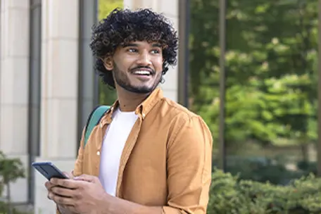 Imagem de um homem sorrindo usando o smartphone.