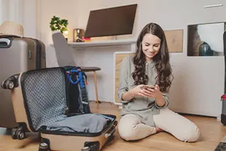 Imagem de uma moça de cabelos longos sorrindo usando o smartphone.