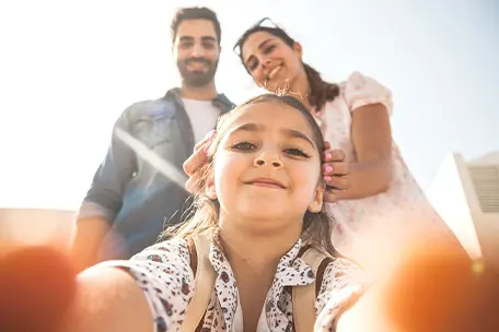 Imagem de uma família sorrindo e tirando fotos.