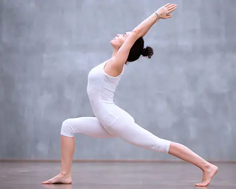 Imagem de uma moça vestindo roupas brancas praticando exercícios.