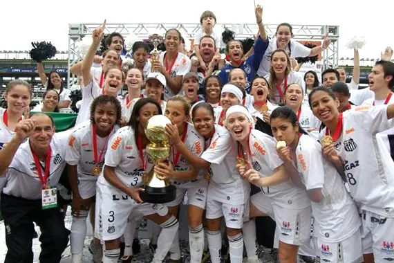 Imagem de jogadoras de futebol levantando o troféu da CONMEBOL Libertadores feminina.