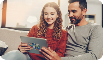Pai e filha usando um tablet no sofá