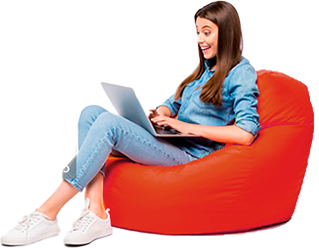 Mulher sorrindo sentada em um puff e usando um notebook